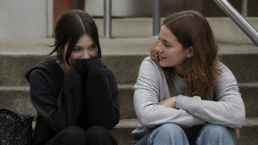 Two teenage girls talking, one comforting the other